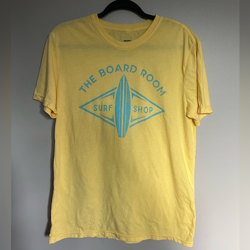 A men’s M yellow T that says “Board Room: Surf Shop”. It’s in great condition.